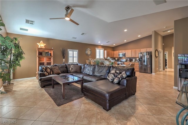 tiled living room with ceiling fan and high vaulted ceiling