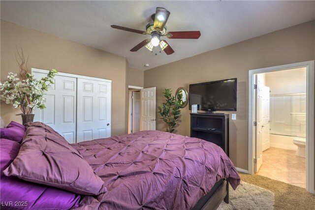 carpeted bedroom featuring a closet, ceiling fan, and ensuite bathroom