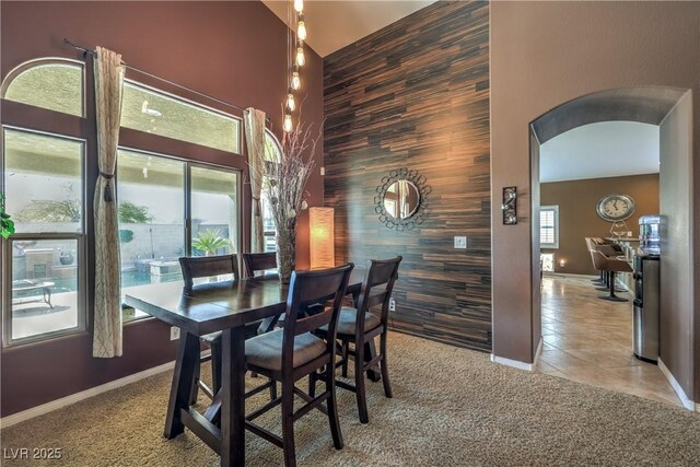 dining room featuring a high ceiling and light tile patterned flooring