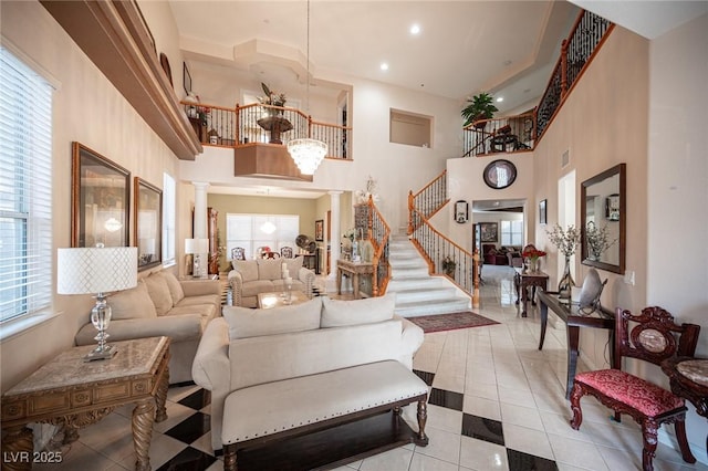 living room with decorative columns, plenty of natural light, and a towering ceiling