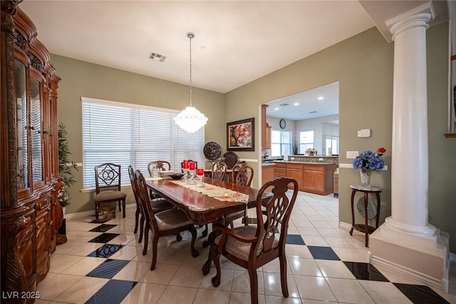 dining space featuring an inviting chandelier, light tile patterned floors, and decorative columns