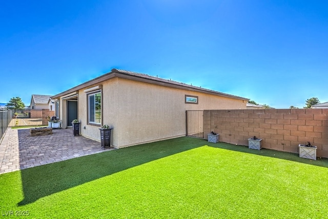 rear view of house featuring a patio area and a lawn