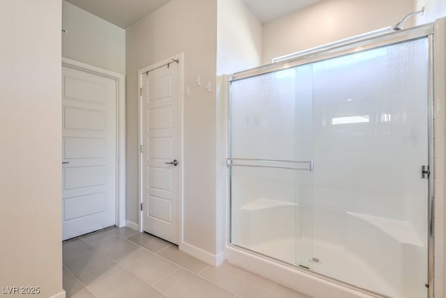 bathroom with tile patterned flooring and a shower with door