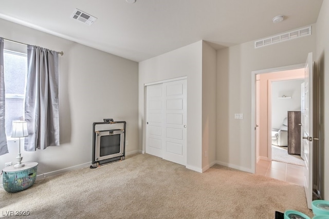 unfurnished bedroom with light colored carpet and a closet