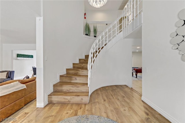 stairs with a high ceiling and wood-type flooring