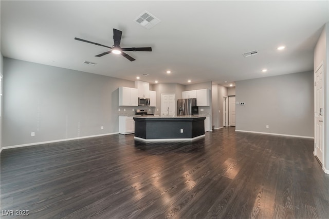 unfurnished living room featuring ceiling fan, sink, and dark hardwood / wood-style flooring