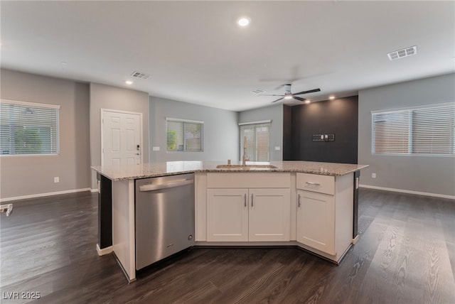 kitchen with dishwasher, white cabinets, a center island, light stone countertops, and dark wood-type flooring