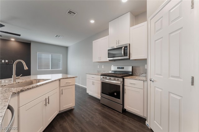 kitchen featuring stainless steel appliances, sink, white cabinets, and light stone counters