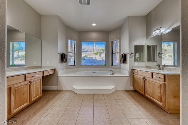 bathroom with vanity, a tub, and tile patterned floors