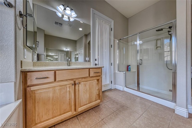 bathroom with an enclosed shower, vanity, and tile patterned floors