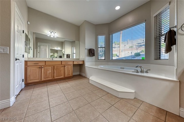 bathroom with tile patterned floors, vanity, and a tub