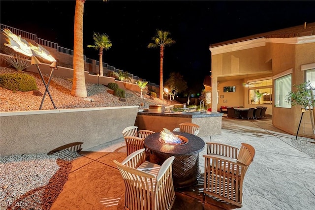 patio at twilight featuring an outdoor bar and an outdoor fire pit