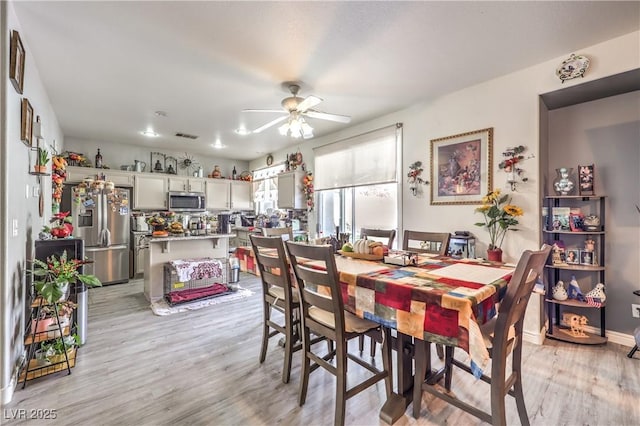 dining space featuring ceiling fan and light wood-type flooring