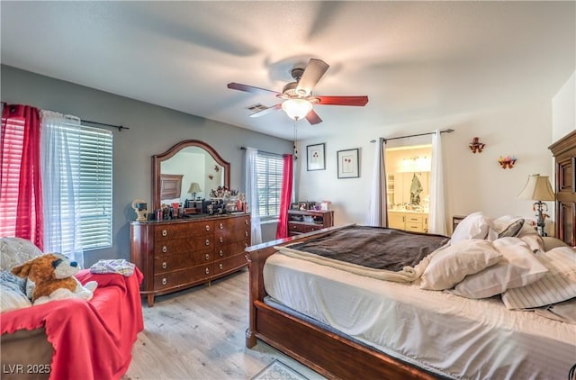 bedroom featuring light hardwood / wood-style floors, ceiling fan, and ensuite bathroom