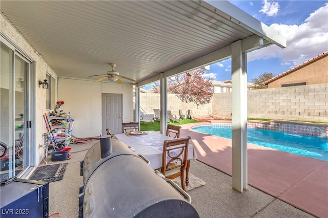 view of patio with a fenced in pool, pool water feature, and ceiling fan