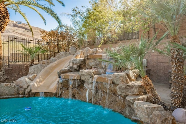 view of swimming pool featuring fence