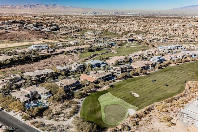 drone / aerial view with view of golf course, a mountain view, and a residential view