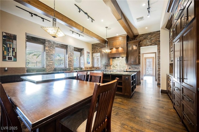 dining room featuring beam ceiling, visible vents, track lighting, and dark wood-style floors