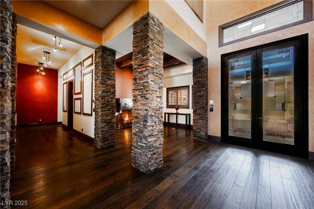 entryway featuring decorative columns, baseboards, and hardwood / wood-style flooring