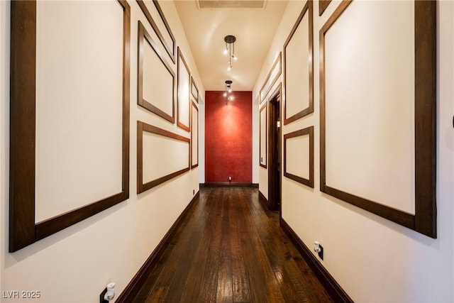 hall with dark wood-style floors and baseboards