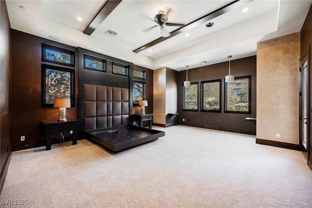 living area with visible vents, baseboards, carpet, a raised ceiling, and a ceiling fan