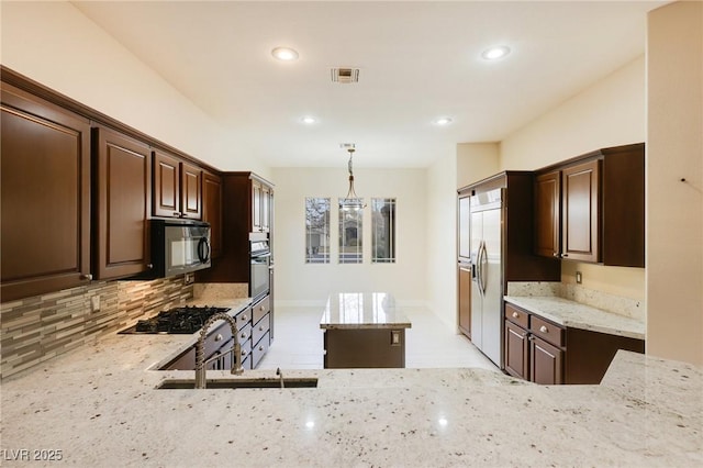 kitchen featuring pendant lighting, sink, light stone counters, black appliances, and dark brown cabinets