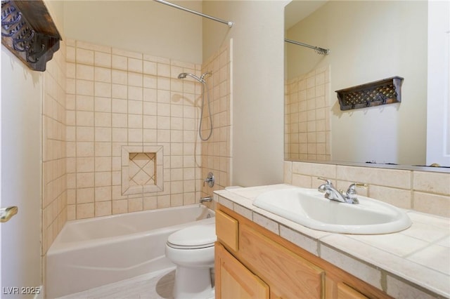 full bathroom with tiled shower / bath, vanity, and toilet