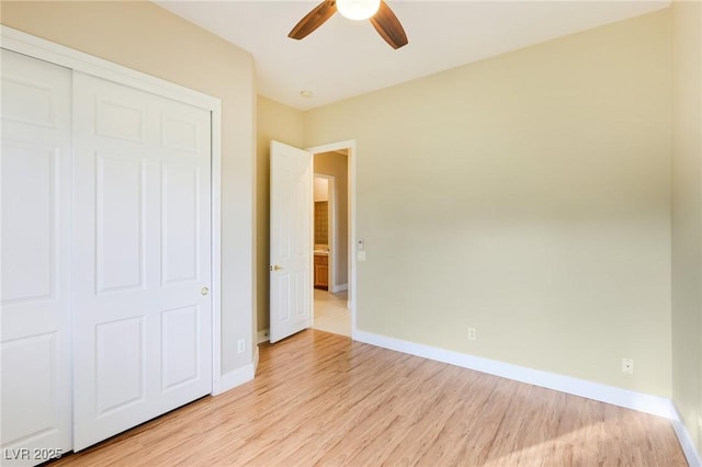 unfurnished bedroom with ceiling fan, a closet, and light wood-type flooring