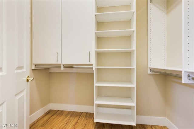 walk in closet with hardwood / wood-style floors