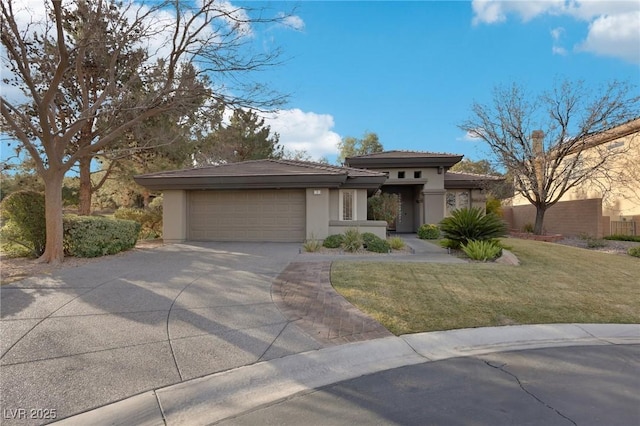 prairie-style house featuring a garage and a front lawn