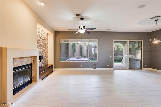 unfurnished living room featuring a fireplace and ceiling fan