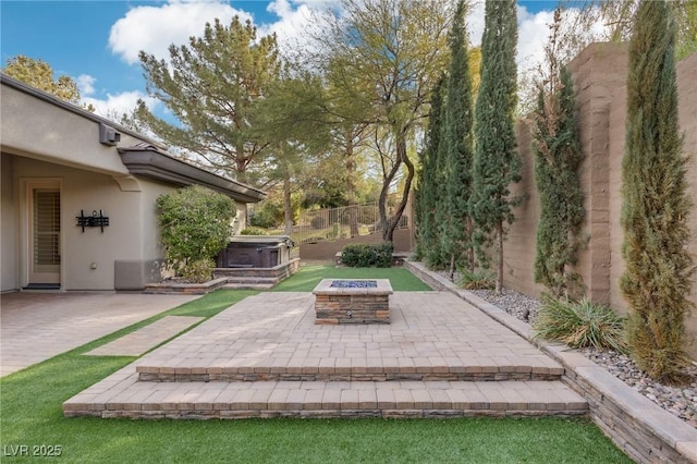 view of patio with a hot tub and an outdoor fire pit