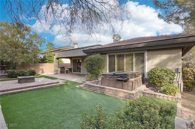 back of house with a patio, a hot tub, a fire pit, and a lawn