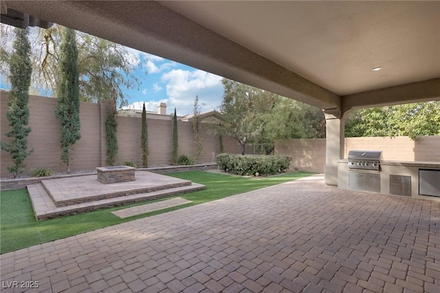 view of patio with an outdoor kitchen, an outdoor fire pit, and area for grilling