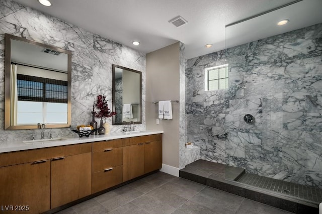 bathroom featuring tiled shower and vanity