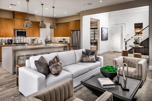 living room with sink and light hardwood / wood-style flooring