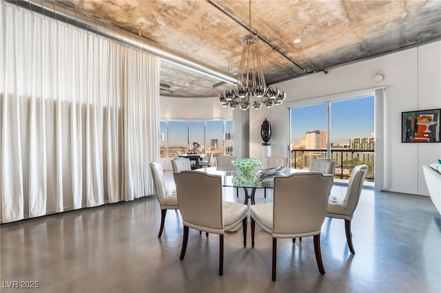 dining area featuring a notable chandelier and concrete floors