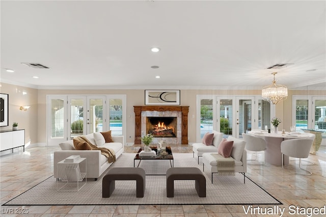 living room featuring an inviting chandelier, plenty of natural light, ornamental molding, and french doors