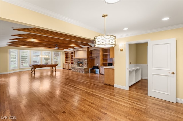 unfurnished living room with billiards, a fireplace, ornamental molding, wood-type flooring, and beamed ceiling