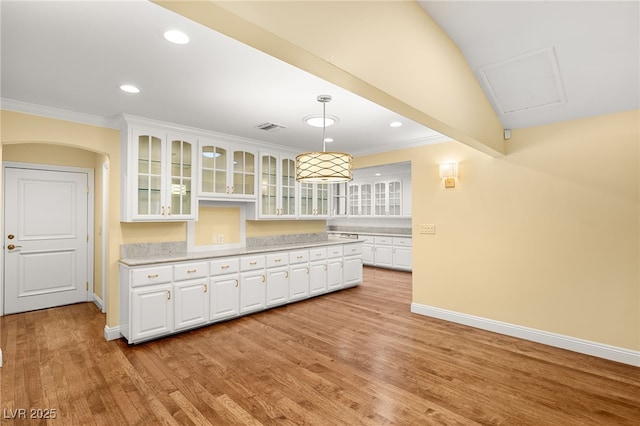 kitchen featuring ornamental molding, pendant lighting, white cabinets, and light hardwood / wood-style flooring