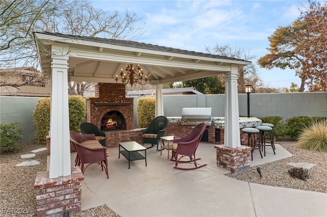 view of patio / terrace featuring an outdoor kitchen, a gazebo, grilling area, an outdoor brick fireplace, and exterior bar