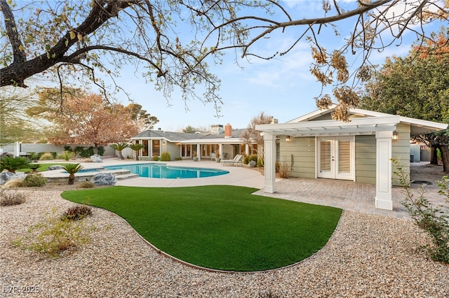 view of swimming pool featuring french doors, a patio, a yard, and a pergola