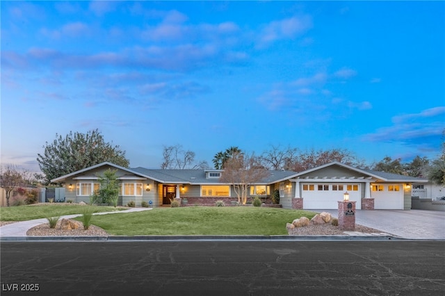 ranch-style house featuring a garage and a yard