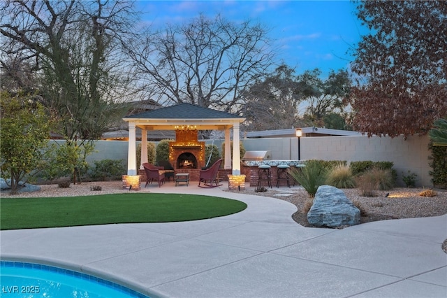 exterior space with an outdoor fireplace and a patio