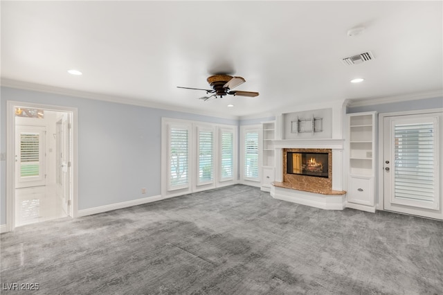 unfurnished living room featuring crown molding, carpet, and a fireplace