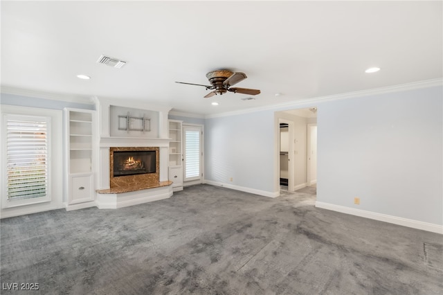 unfurnished living room featuring crown molding, carpet floors, ceiling fan, and a fireplace