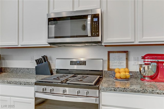 kitchen featuring white cabinetry, appliances with stainless steel finishes, and light stone countertops