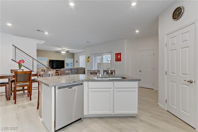 kitchen featuring sink, light hardwood / wood-style flooring, white cabinetry, a center island with sink, and stainless steel dishwasher