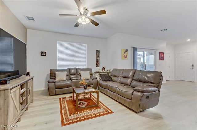 living room with light hardwood / wood-style flooring and ceiling fan