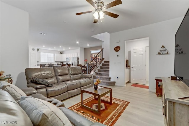 living room featuring ceiling fan and light hardwood / wood-style flooring